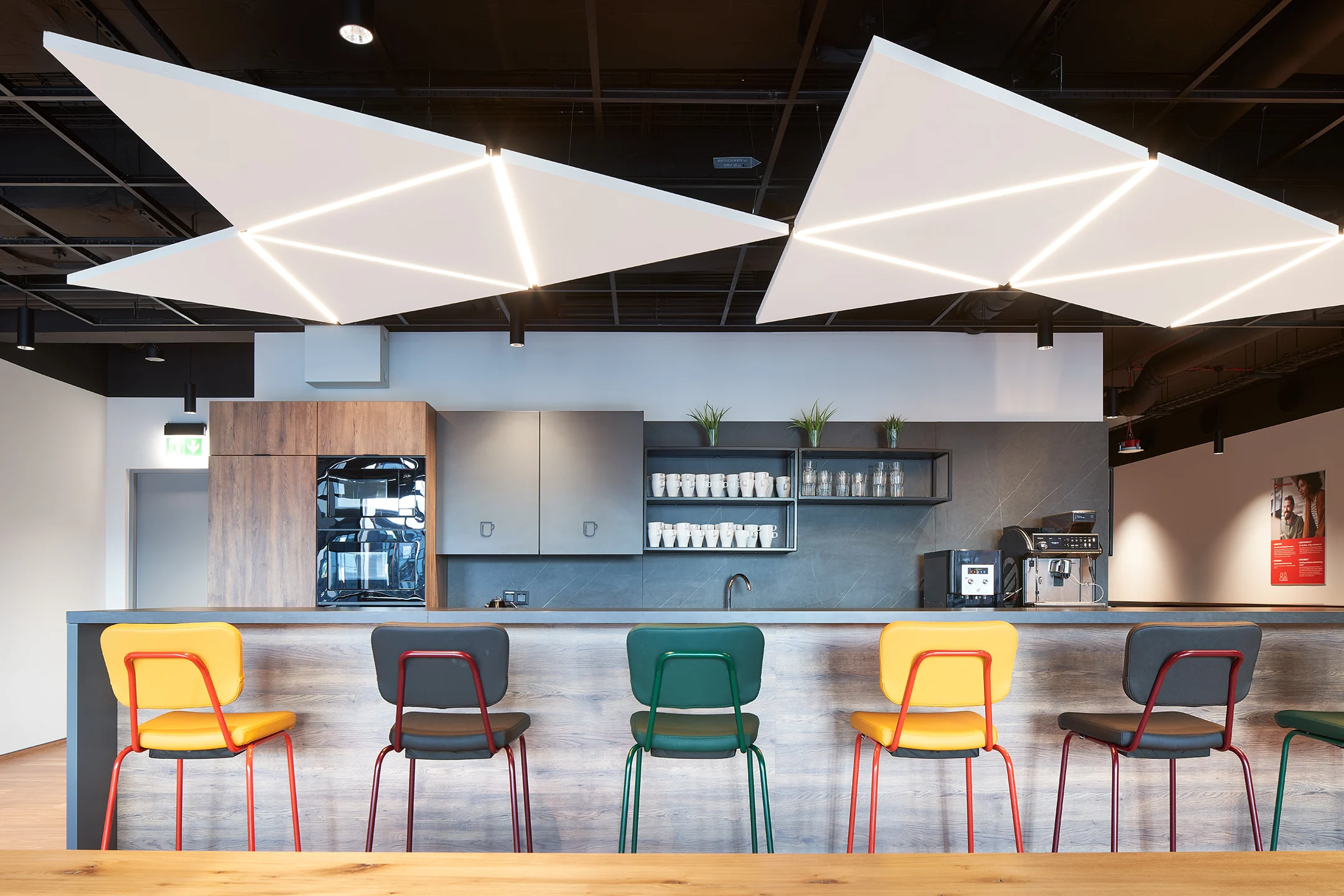 White triangle suspended acoustic ceiling tiles in a beautiful breakout area